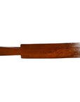 Brown wood antique Chinese rice mold with four rosette cavities and long handle on plain white background.