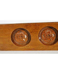 Close-up of a brown antique Chinese rice mold, wood material, with four round seal cavities and intricate calligraphy detail.