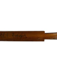 Brown wooden antique Chinese rice mold with four round seal cavities and carved calligraphy detail, close-up view.