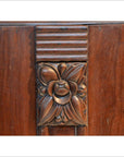 Dark rosewood side table with carved floral center and horizontal grooves, shown in a neutral setting.