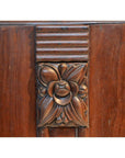 Dark rosewood side table with carved floral center and horizontal grooves, shown in a neutral setting.