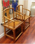 Brown wood antique Chinese side chairs with carved backs, displayed side by side on polished wooden floor.
