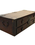 Dark wood Chinese chest with metal handles, two drawers, and decorative metal accents on front and corners, close-up.