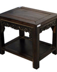 Small brown wood antique Chinese coffee table with hand-carved details and lower shelf, on white background.