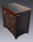 Close-up of antique Chinese small dark brown lacquer cabinet with two drawers and doors, aged, on gray background.