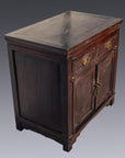 Close-up of small dark brown lacquered Chinese cabinet with two drawers, two doors, brass handles, and decorative lock.