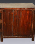 Dark brown lacquered wood antique Chinese cabinet against a dark background.