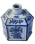 Blue and white ceramic sake bottle with hand painted floral design, narrow neck, close-up on white background.
