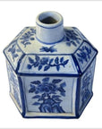Blue and white ceramic sake bottle with hand painted floral design, narrow neck, close-up on white background.