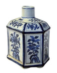 White porcelain sake bottle with blue hand painted floral designs, hexagonal shape, and narrow neck, close-up.