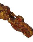 Close-up of antique wooden reclining figure with gold and red paint, weathered texture, Chinese temple carving.
