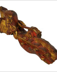 Close-up of antique wooden reclining figure with gold and red paint, weathered texture, Chinese temple carving.