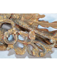 Close-up of weathered gold wood Chinese temple carving with intricate floral and bird motifs.
