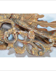 Close-up of weathered gold wood Chinese temple carving with intricate floral and bird motifs.
