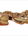 Close-up of a gold and red painted wooden fish carving with decorative accents, antique Chinese temple art.