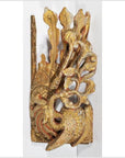 Close-up of antique Chinese temple carving in ornate red and gold wood, with stylized bird and detailed feathers.
