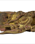 Close-up of antique Chinese temple carving featuring intricate dragon design, weathered wood, and faded gold-red paint.