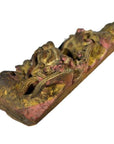 Close-up of antique Chinese temple carving in weathered gold and red wood with ornate swirling vintage patterns.