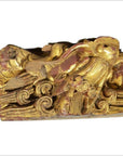 Gold and red wood temple carving with bird among swirling clouds, intricate detailing, close-up view.