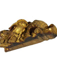 Gold wood Chinese temple carving close-up with intricate patterns and a mythic fish among swirling waves.