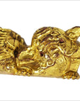 Close-up of gold-colored carved wooden dragon figures with red eyes, ornate design, pair shown together.