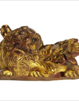 Gold and red antique Chinese dragon temple carving with detailed mane, lying down, one paw raised, close-up view.