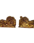 Close-up of gold-tone dragon-shaped antique Chinese temple carvings with intricate details, facing each other.
