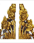 Gold and white wood temple carvings, pair, with intricate floral and leaf designs, close-up view.