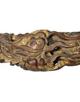 Gold-brown carved wood Chinese temple sculptures with swirling finish and stylized mythical creatures, close-up view.