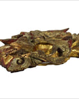 Close-up of gold and red wood Chinese temple carvings pair with ornate scroll and leaf patterns.