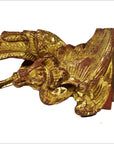 Gold-painted wood carvings, pair of winged mythical creatures with feather and scale details, antique style.