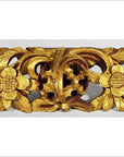 Close-up of gold-painted wood Chinese temple carvings with floral and leaf motifs and a central medallion.