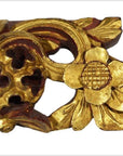 Close-up of gold-painted wood temple carvings with intricate floral and leaf designs, pair displayed together.