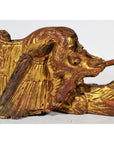 Close-up of gold and red wood griffin carving with intricate wings and lion-like face from antique Chinese temple.