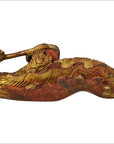 Close-up of ornate gold and red wood Chinese temple carvings pair with intricate curved edges.