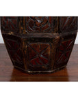 Close-up of a brown wooden antique Chinese wedding box with carved handle, animal and foliage motifs on a wooden surface.