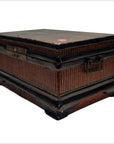 Brown wood and rattan Chinese box with metal handles and short curved legs, close-up.