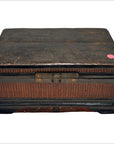 Close-up of dark wood and rattan Chinese box with woven sides and small pink sticker on the top right corner.