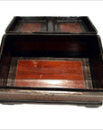 Dark wood and rattan box with reddish-brown interior, lid propped open, shown in a simple setting.