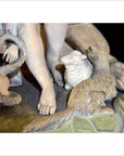 Bronze-colored European statue with snake, human feet, lamb, and fox on a textured base, close-up view.