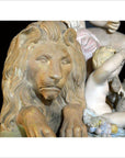 Bronze-colored European statue of a lion beside a small child, detailed sculpting, displayed indoors.