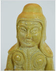 Close-up of antique glazed terracotta warrior statue with detailed features and circular chest patterns.
