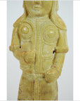 Yellow glazed terracotta warrior figure with geometric chest patterns, hands at waist, intricate detailing, close-up.