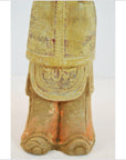 Close-up of lower half of antique glazed terracotta warrior, detailed robe, ornate gold-colored shoes visible.