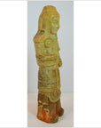 Side view of antique glazed terracotta warrior statue with detailed armor, headdress, and faded orange accents.