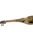 Close-up of an antique hand-carved wood Indian lute sitar ladle with detailed scrollwork and tuning pegs on the handle.