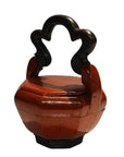 Red lacquered wood Chinese wedding basket with intricate black carved handle and matching lid, close-up view.