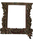 Brown wood hand-carved mirror frame with intricate floral carvings and small bird accent, close-up view.