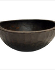 Close-up of dark wood hand-carved round offering bowl with textured exterior on a white background.