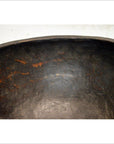 Close-up of a dark wooden hand-carved antique offering bowl with a weathered finish and brownish streaks inside.